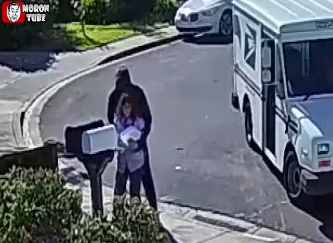 Video :A man robs a postwoman at gunpoint, taking her phone and mailbox keys